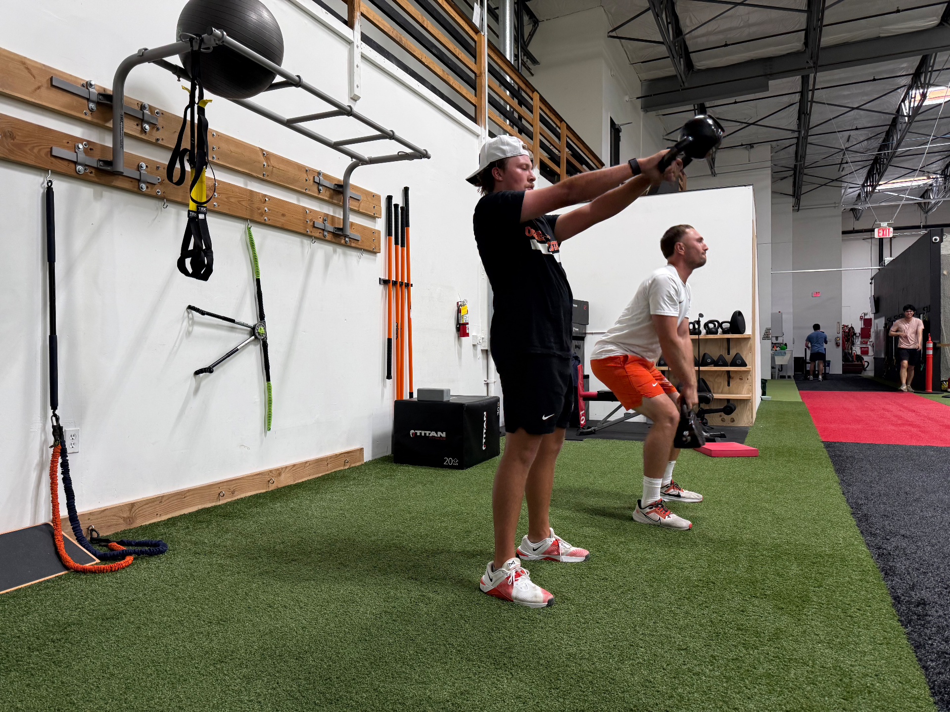 A coach working with a golfer on the training floor at Portland Indoor Golf Club