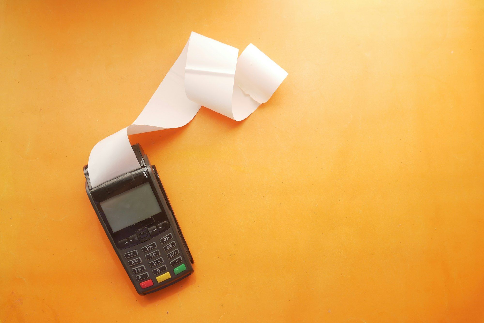 A card payment terminal printing a long receipt