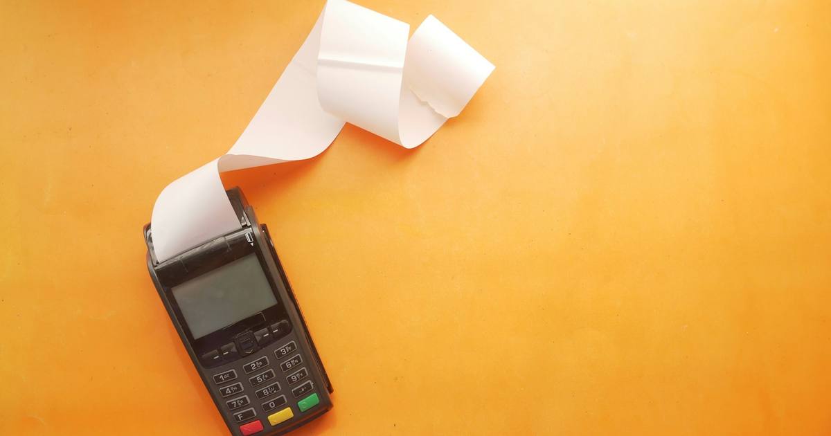 A card payment terminal printing a long receipt